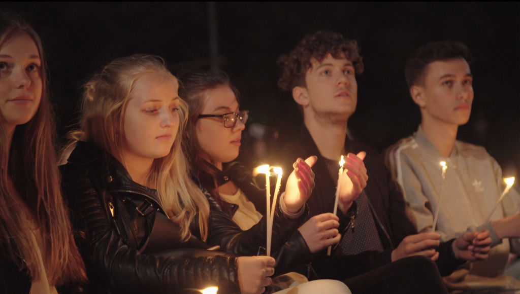 Modlitwa wieczorna młodzieży trzymającej w dłoni świeczki